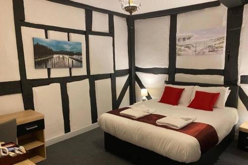 TitchfieldThe Bugle Hotel的一间卧室配有一张带红色枕头的大床