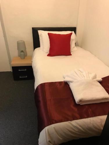 TitchfieldThe Bugle Hotel的一间卧室配有一张红色枕头的床