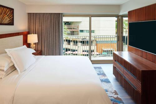 檀香山Hilton Grand Vacations Club Hokulani Waikiki Honolulu的酒店客房设有一张大床和一台电视。