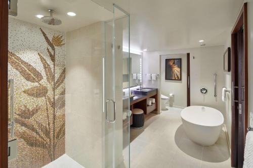 檀香山Hilton Grand Vacations Club Hokulani Waikiki Honolulu的带浴缸和玻璃淋浴间的浴室