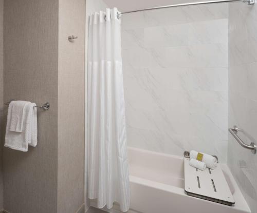休斯顿休斯顿北希尔顿酒店的一间带白色淋浴帘的浴室