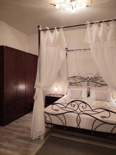 阿洛尼索斯古镇Cherry's apartment的卧室配有一张带白色窗帘的大床