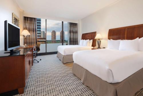 休斯顿休斯敦波斯特奥克希尔顿广场酒店 的酒店客房设有两张床和一台平面电视。