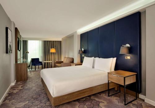 林肯林肯希尔顿逸林酒店的卧室配有一张白色大床和蓝色的墙壁