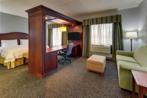 印第安纳波利斯印第安纳波利斯机场汉普顿套房酒店的配有一张床和一张书桌的酒店客房