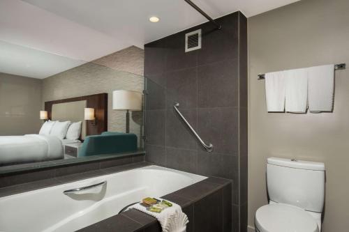 蒙罗维亚蒙罗维亚希尔顿逸林酒店 - 帕萨迪纳区的带浴缸、床和卫生间的浴室