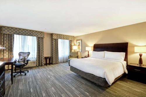 里奇菲尔德帕克里奇菲尔德公园希尔顿花园酒店的酒店客房设有一张大床和一张书桌。