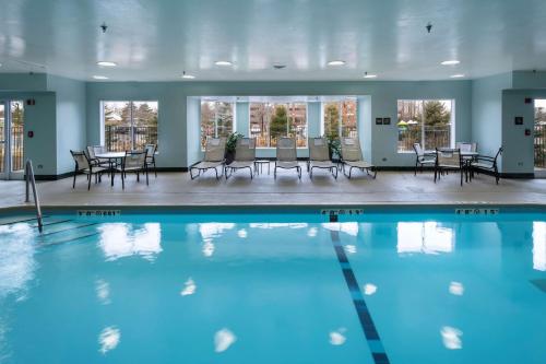 林肯郡林肯郡希尔顿恒庭旅馆&套房酒店的大楼内一个带桌椅的游泳池
