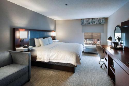 林肯郡林肯郡希尔顿恒庭旅馆&套房酒店的酒店客房配有一张床、一张桌子和一把椅子。