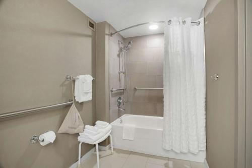 小石城小石城希尔顿逸林酒店的浴室配有浴缸和淋浴及浴帘