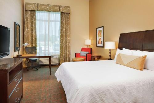 曼哈顿希尔顿曼哈特昂卡恩萨斯希尔顿酒店的酒店客房配有一张床、一张书桌和一台电视。