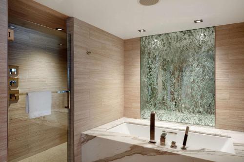 泰森斯角麦克莱恩泰森斯科纳希尔顿酒店的设有带浴缸和淋浴的浴室。