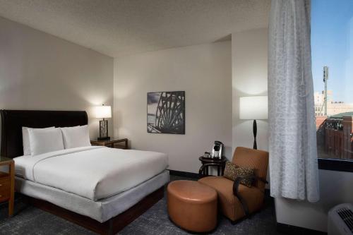 孟菲斯希尔顿逸林酒店孟菲斯市中心的配有一张床和一把椅子的酒店客房
