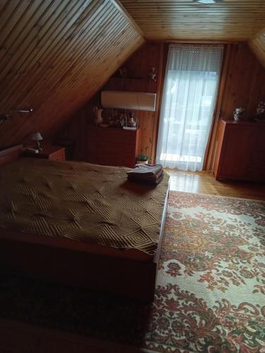 WilczeMarianówka的一间卧室设有一张带木制天花板的大床