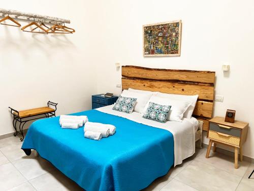 特拉尼TornaRé的一间卧室配有蓝色的床和毛巾