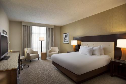 奥克兰奥克兰希尔顿机场酒店的酒店客房,配有床和电视