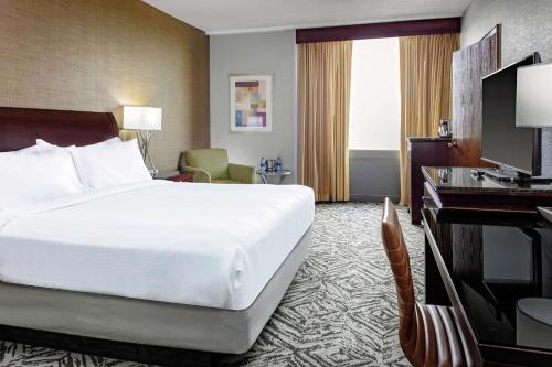 奥马哈奥马哈市中心希尔顿逸林酒店及商务会议中心的酒店客房设有一张大床和一张书桌。
