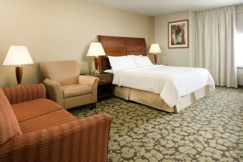 奥马哈西奥马哈希尔顿花园酒店的配有一张床和一把椅子的酒店客房