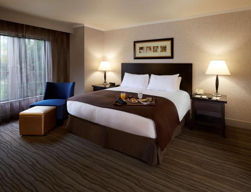 克莱蒙特克莱尔蒙特希尔顿逸林酒店的酒店客房带大床和蓝椅