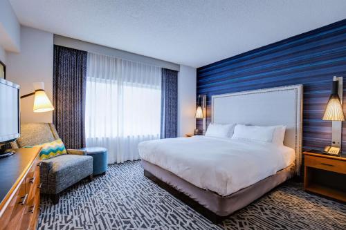 唐纳斯格罗夫芝加哥-唐纳斯格罗夫希尔顿逸林套房酒店&会议中心的酒店客房带一张大床和一把椅子