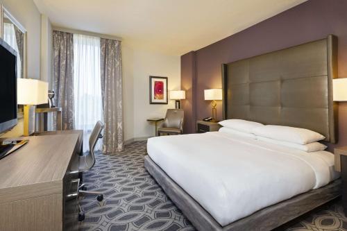 奥兰多东奥兰多UCF区希尔顿逸林酒店的酒店客房设有一张大床和一张书桌。