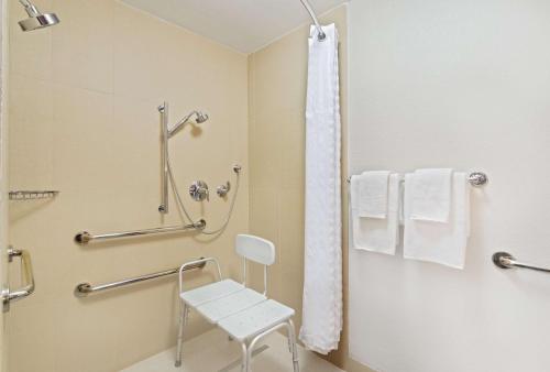 奥兰多东奥兰多UCF区希尔顿逸林酒店的一间带白色椅子和淋浴的浴室