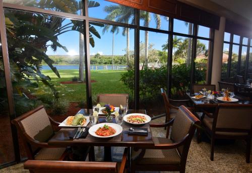 西棕榈滩Hilton Palm Beach PBI的一间设有桌椅和盘子的餐厅