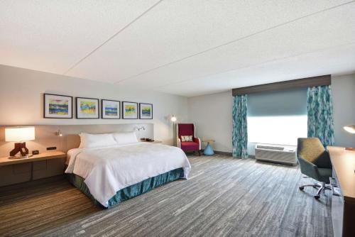 巴拿马城巴拿马城希尔顿花园酒店的配有一张床、一张书桌和一扇窗户的酒店客房
