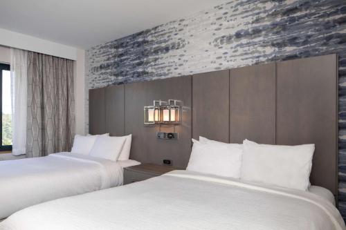 波特兰缅因州波特兰希尔顿合博套房酒店的配有白色床单的酒店客房内的两张床