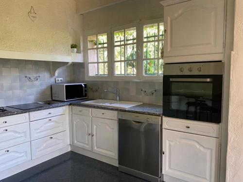 雷以桑布尔Villa “mas provençale”的厨房配有白色橱柜和炉灶烤箱。