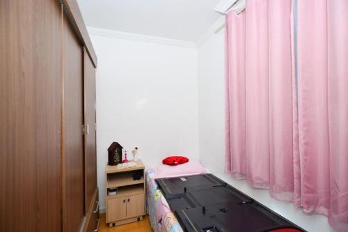 贝洛奥里藏特Exotic Home Brazil的一间卧室配有一张床和粉红色窗帘