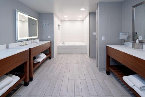 贝克斯菲尔德贝克斯菲尔德逸林酒店的浴室配有两个盥洗盆和浴缸。