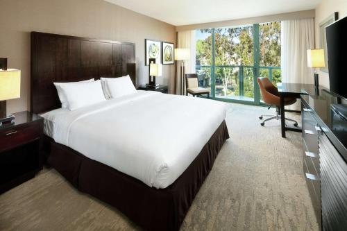 圣地亚哥圣地亚哥圆环希尔顿逸林酒店的酒店客房设有一张大床和一张书桌。
