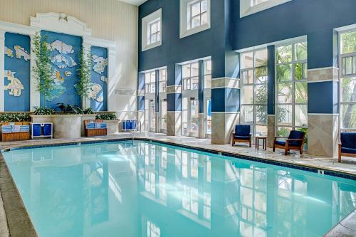 圣地亚哥圣迭戈湾市中心使馆套房希尔顿酒店的一个带蓝色墙壁和窗户的游泳池