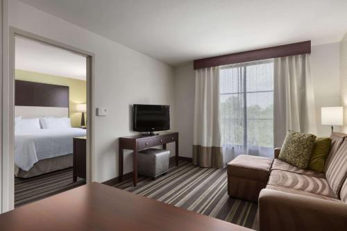 萨凡纳恩柏西萨凡纳机场酒店的酒店客房,配有床和电视