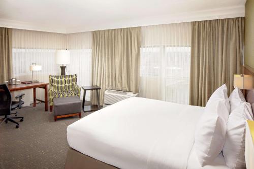 南本德南本德双树希尔顿酒店的酒店客房设有一张白色大床和一张书桌