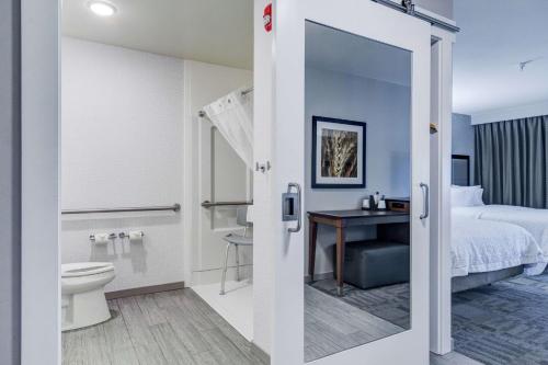 萨利纳萨利纳汉普顿酒店的酒店客房设有带一张床和卫生间的浴室