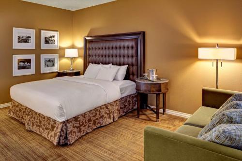 伍德森特瑞斯圣路易斯机场希尔顿酒店的配有一张床和一把椅子的酒店客房