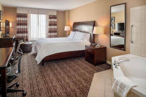 伯克利圣路易斯机场希尔顿花园酒店的酒店客房配有一张床和浴缸。
