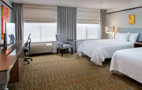 奥法隆圣路易斯/奥法隆希尔顿花园酒店的酒店客房配有两张床和一张书桌