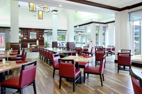 圣罗莎索诺玛郡机场希尔顿花园酒店的餐厅设有木桌和红色椅子
