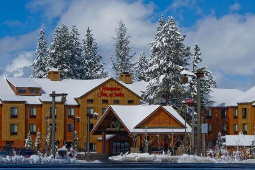 特拉基Hampton Inn & Suites Tahoe-Truckee的雪地小屋,有雪覆盖的树木