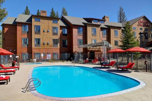 特拉基Hampton Inn & Suites Tahoe-Truckee的游泳池,带椅子和遮阳伞