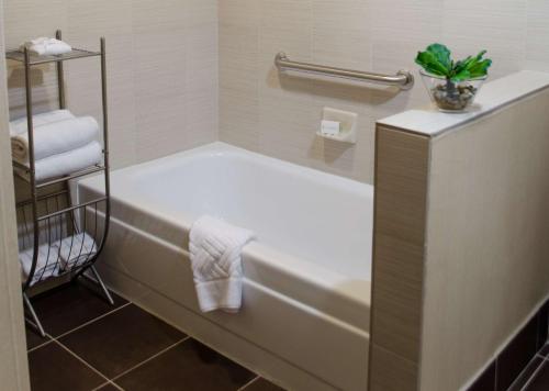 土桑图森机场套房酒店的带浴缸的浴室和毛巾