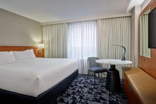 华盛顿Embassy Suites by Hilton Washington DC Convention Center的酒店客房设有一张大床和一张桌子。