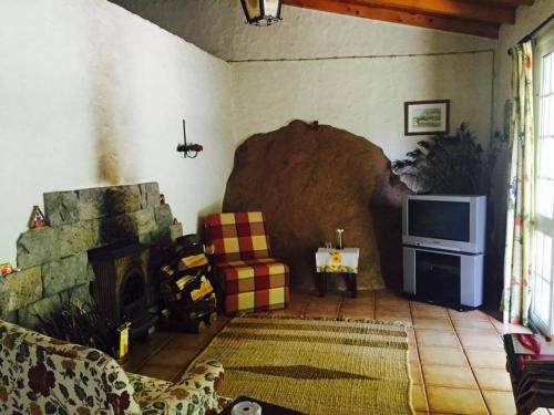 FaialMoinho do Comandante的客厅设有壁炉和电视。
