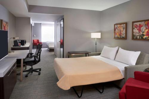 米西索加多伦多西机场/密西沙加希尔顿花园酒店的配有一张床和一张书桌的酒店客房