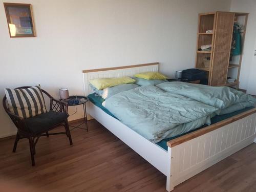不来梅港Ferienwohnung `Ton Utkiek`的一间卧室配有一张大床和一把椅子