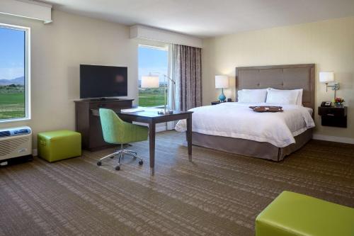 布莱斯加利福尼亚州布莱斯汉普顿酒店及套房的酒店客房配有一张床、一张书桌和一台电视。
