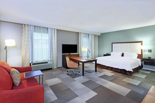 休斯顿德克萨斯休斯顿北IAH汉普顿套房酒店的配有一张床和一张书桌的酒店客房